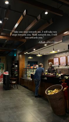 a man standing in front of a counter at a restaurant with a quote on it