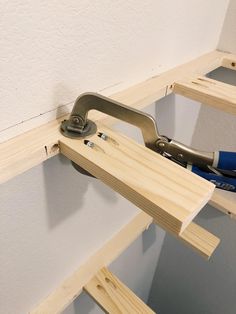 a pair of pliers are sitting on the edge of a piece of wood that is being built