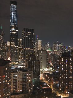 the city skyline is lit up at night with skyscrapers in the foreground and lights on