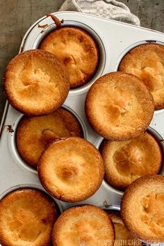 muffin tins filled with baked goods sitting on top of a wooden table