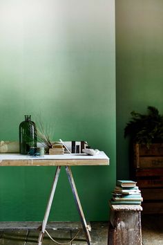 a table that has some books on it next to a vase and other items sitting on top of it