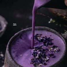 a purple drink being poured into a cup