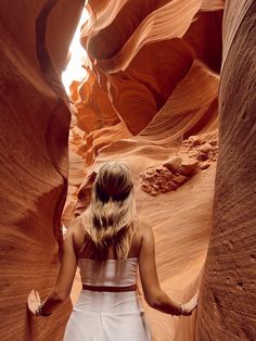 a woman in white dress walking through slot formations