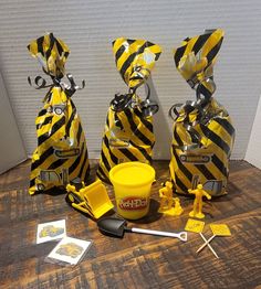 three yellow and black striped bags sitting on top of a wooden table next to utensils