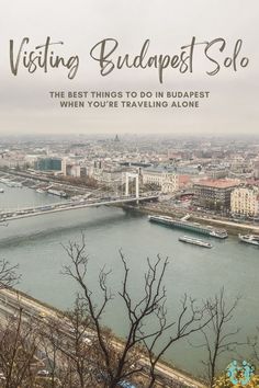 an aerial view of a river and bridge with the words visiting budapest solo