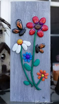 a painting with flowers and butterflies painted on it's side, sitting on a table