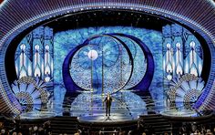 the stage at the oscars is lit up with blue lights and an artistic design