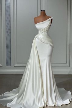 a white wedding dress with an off the shoulder neckline and beading on it