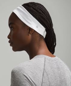 a woman wearing a white headband and looking off to the side