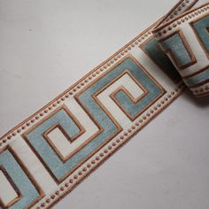 a white and blue ribbon with gold trimmings on the edge, sitting on top of a table