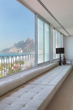 there is a large window that looks out onto the beach and mountains in the distance