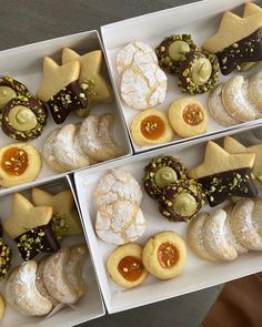 four boxes filled with assorted pastries on top of a table