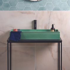 a bathroom sink sitting under a mirror next to a tiled wall