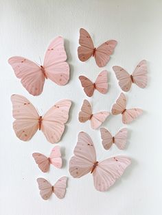 pink butterflies are arranged on the wall