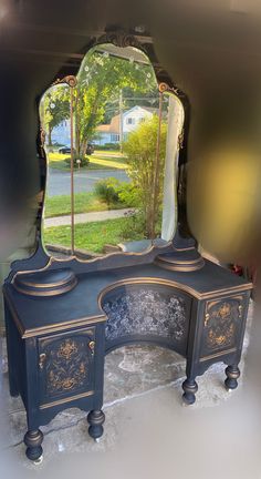 an antique vanity with a large mirror on it's top and side panels, in front of a house