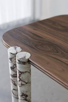 two marbled candles are sitting on a wooden table