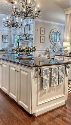 a kitchen with an island and chandelier hanging from the ceiling