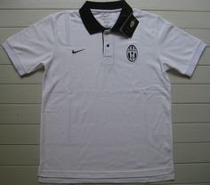 a white nike polo shirt with black collar and logo on the left chest, in front of a wall