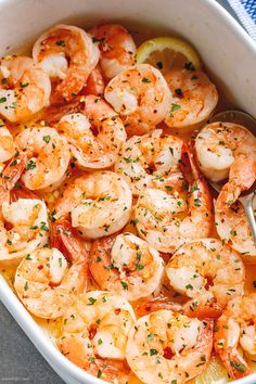 a white bowl filled with shrimp and lemon