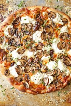 a pizza topped with mushrooms and cheese on top of a table