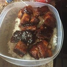 a plastic container filled with meat and rice