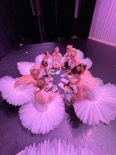 a group of women in tutu skirts sitting around a table