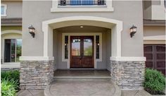 the front entrance to a house with stone pillars