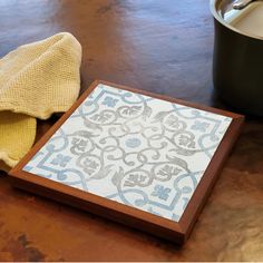 a wooden tray sitting on top of a table next to a pot and a towel