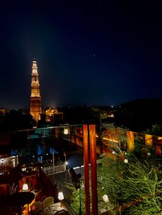 a view of a clock tower at night from a rooftop restaurant in the city center