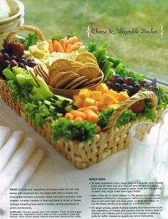 a basket filled with fruits and vegetables on top of a white table cloth next to a window