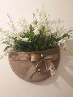 a basket with flowers in it hanging on the wall