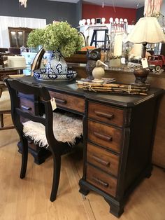 an antique desk with lots of furniture on display in a store or home decor showroom