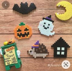 halloween magnets made out of perler beads on a wooden table with the words trick or treat written in it