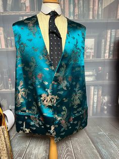 A very bold and bright waistcoat  No label but appears to be Silk  Also appears to be brand New  Make: No label  Origin: Great Britain (possibly)  Style: Beautiful Bold Dragon Silk pattern   5 button front with watch chain vertical hole  2 pockets to front  Material: Silk.. we think  Colour: Blue with Dragon pattern  Condition: Appears to be new  Size: 54"/137cm chest  Armpit to Armpit: 27"/69cm  Shoulder seam to Bottom point: 30"/76cm  Back: 27"/68cm  PLEASE NOTE: This item is "Vintage style" a Colourful Waistcoat, Chinese Dragon Pattern, Chinese Pattern, Silk Pattern, Dragon Pattern, Vest Pattern, Chinese Dragon, Watch Chain, Design Drawing