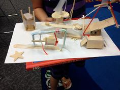 a group of people standing around a table with some wooden toys on top of it