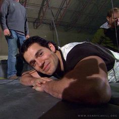 a man laying on top of a bed next to a person in a black shirt