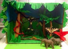 an elephant and other animals are in a jungle scene made out of paper mache