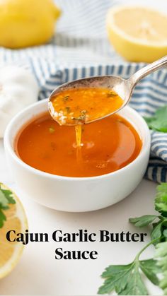 a spoon full of tomato soup with parsley on the side and lemons in the background