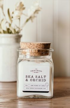 a glass jar with sea salt and orchids in it