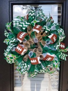 a wreath made out of paper rolls and footballs on the side of a door