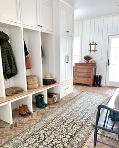 a room with white cabinets and an area rug on the floor in front of it