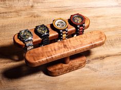 five watches are sitting on top of a wooden stand