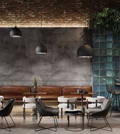 a room with several chairs, tables and lamps hanging from the ceiling in front of a brick wall