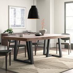 a dining room table with chairs and a vase on it