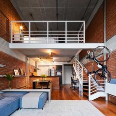 a living room filled with furniture and a bike mounted to the wall next to a stair case