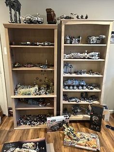 two bookcases filled with toys and books on top of a wooden floor next to each other