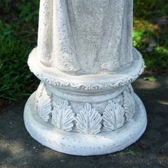 a white statue sitting on top of a cement slab