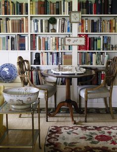 a living room filled with furniture and bookshelves covered in lots of bookcases