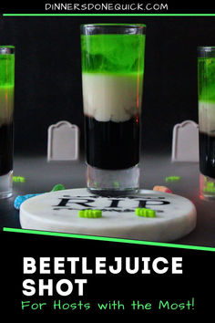 three shot glasses filled with green and white liquid on top of a coaster that says beetlejuice shot for hosts with the most