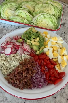 an assortment of chopped vegetables on a plate next to a tray of lettuce